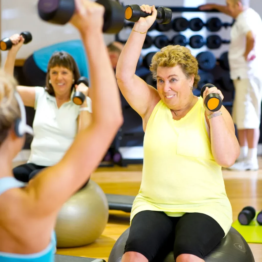 Women exercising with dumbbells in a fitness class.