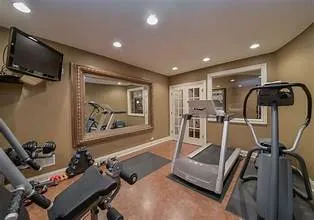 A cozy home gym with treadmill and exercise bike.